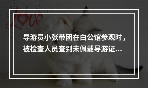 导游员小张带团在白公馆参观时，被检查人员查到未佩戴导游证，