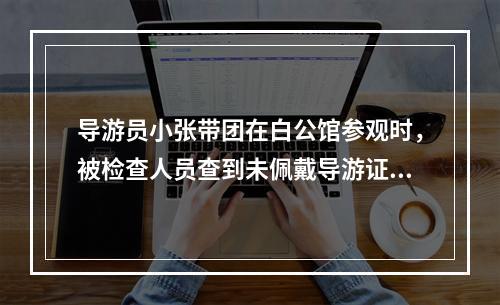 导游员小张带团在白公馆参观时，被检查人员查到未佩戴导游证，