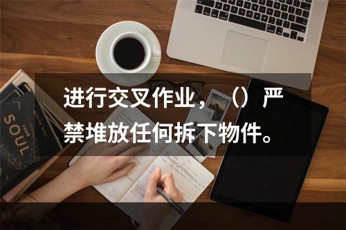 进行交叉作业，（）严禁堆放任何拆下物件。